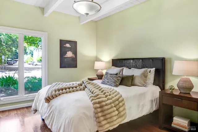 a large bed sitting in a bedroom next to a window