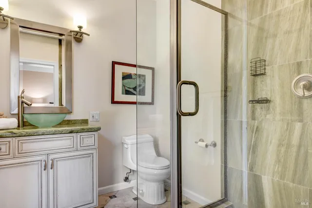 a bathroom with a granite countertop toilet sink and shower