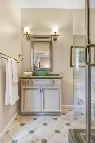 a bathroom with a granite countertop sink and a mirror