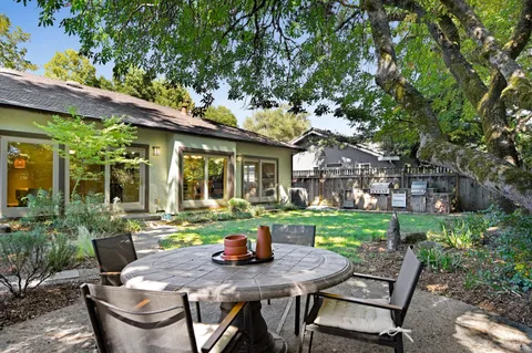 a view of a patio with table and chairs potted plants with large tree