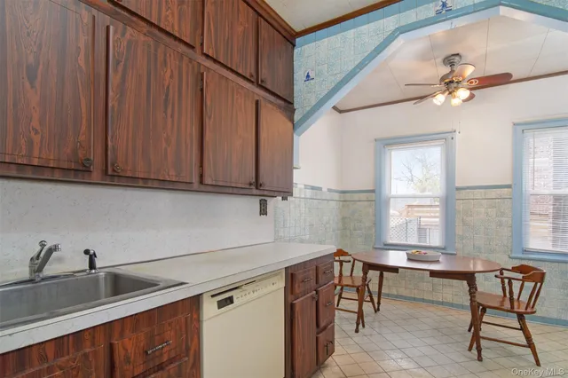 a kitchen with stainless steel appliances granite countertop a sink a stove cabinets dining table and chairs