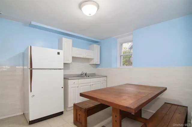 a kitchen with a table chairs refrigerator and sink