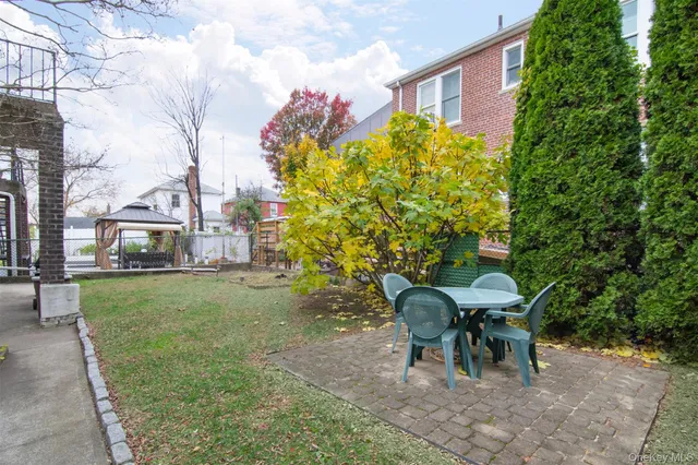 a view of a table and chairs in backyard of the house
