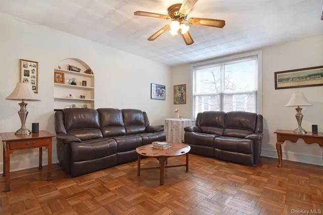 a living room with furniture a ceiling fan and a window