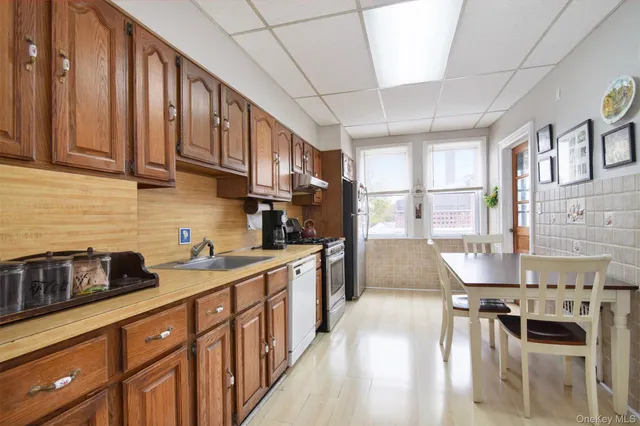 a kitchen with stainless steel appliances granite countertop a stove a sink dishwasher and cabinets with wooden floor