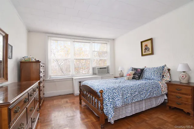 a bedroom with a bed and a dresser next to a window