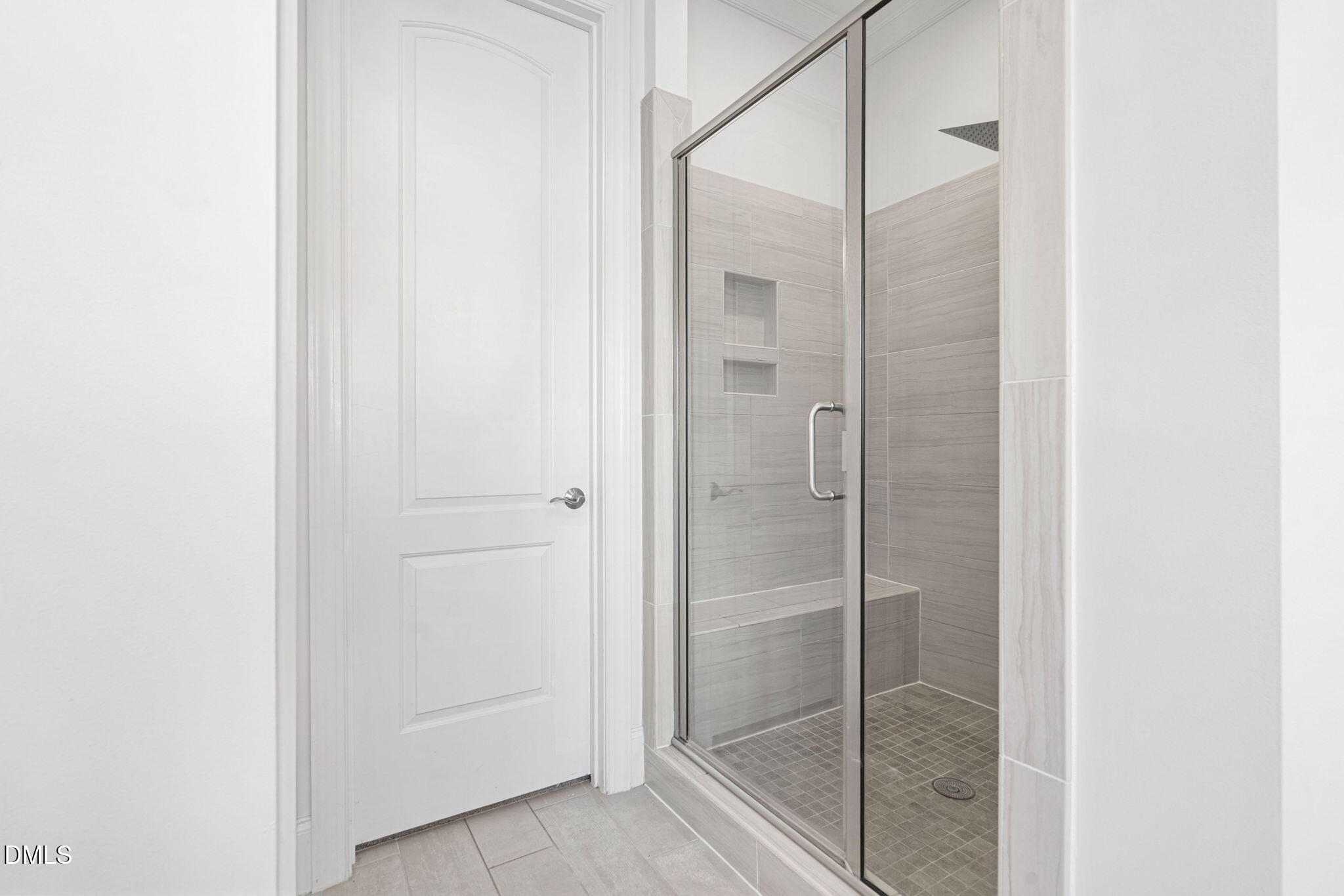 2414 Vetrina Way Apex, NC 27502 - Photo 25 of 60 a bathroom with a glass shower door