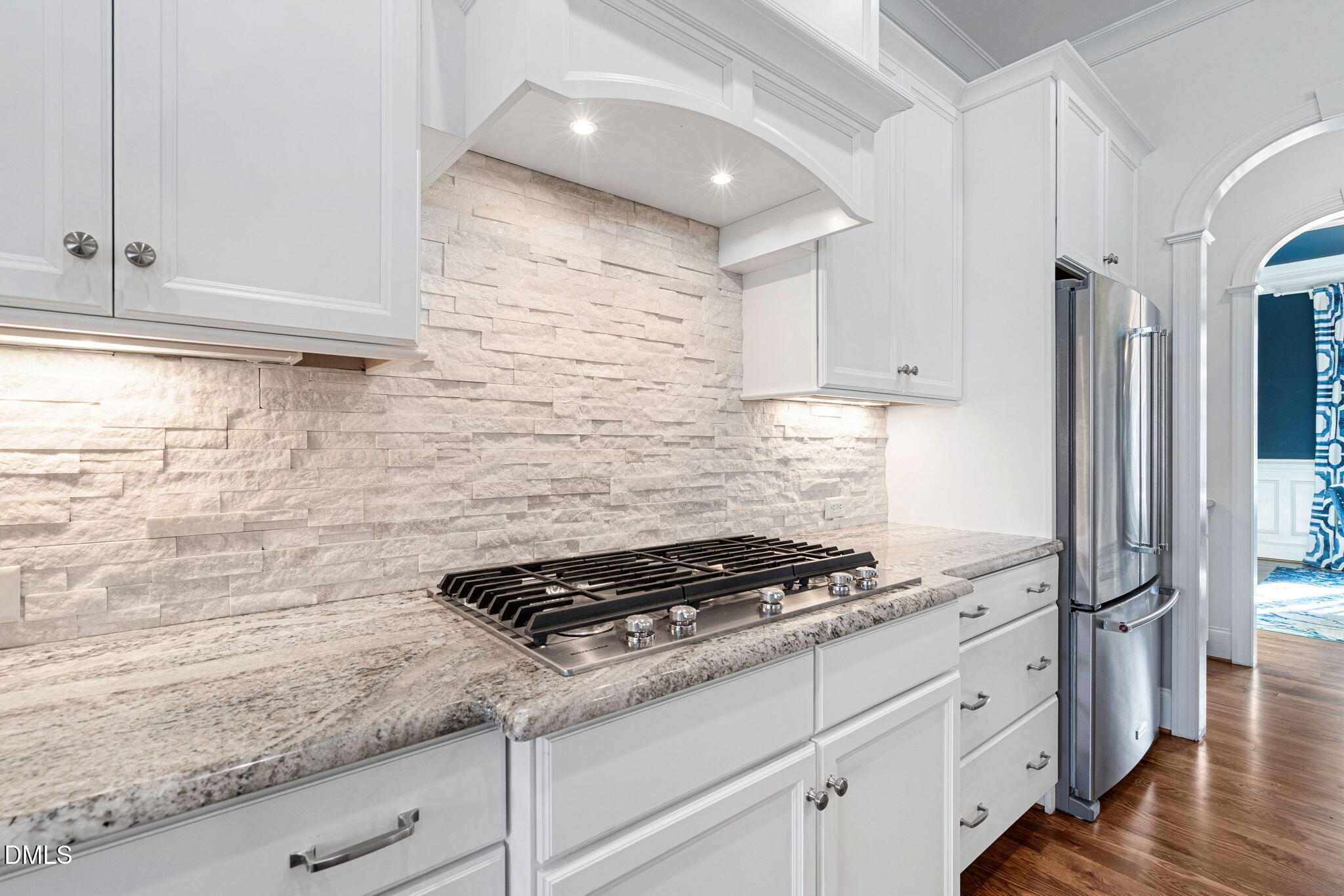 2414 Vetrina Way Apex, NC 27502 - Photo 7 of 60 a kitchen with white cabinets and a stove