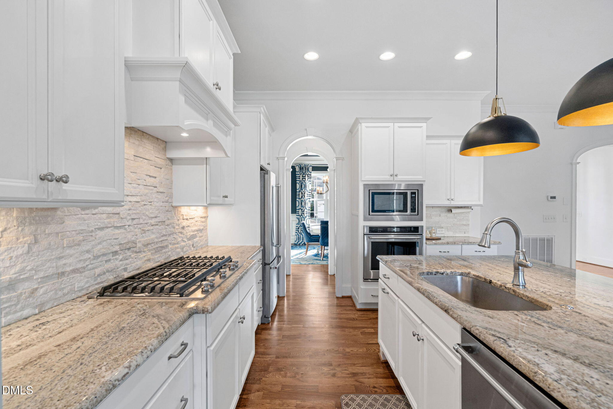 2414 Vetrina Way Apex, NC 27502 - Photo 8 of 60 a large kitchen with stainless steel appliances granite countertop a stove a sink a refrigerator and a wooden cabinets