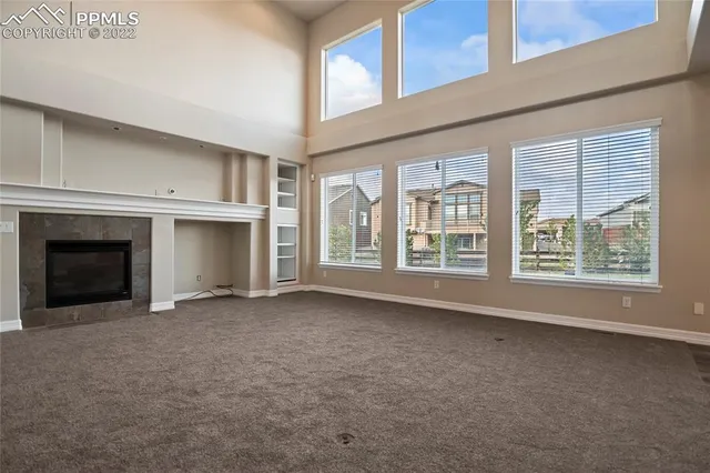 an empty room with a ceiling fan and carpet
