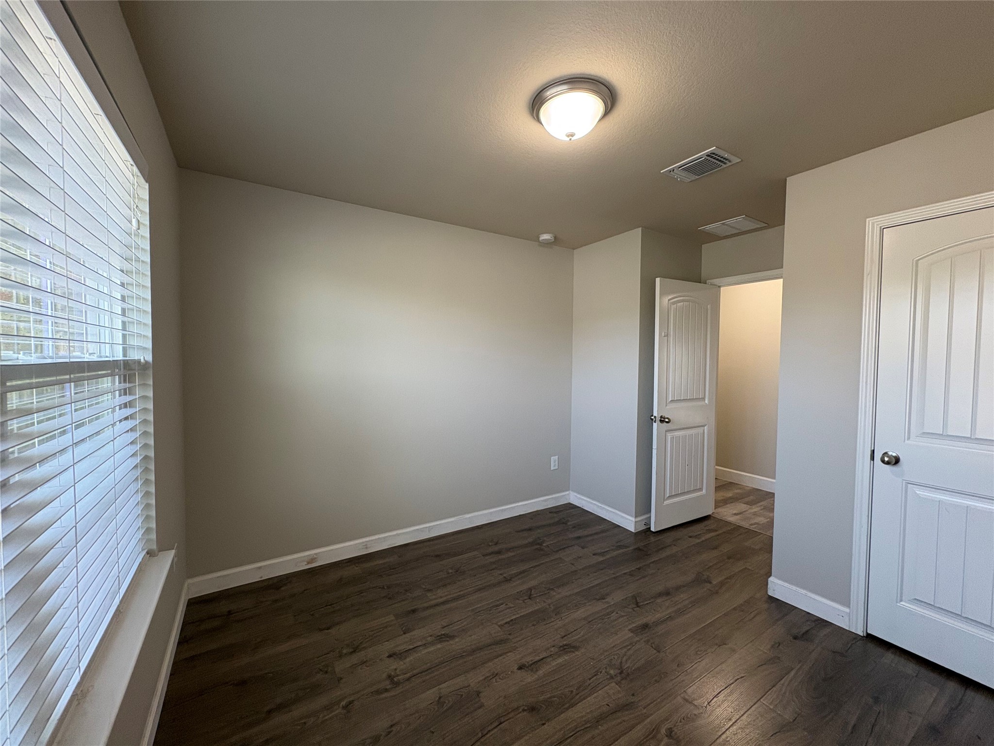 11708 Cambrian Road Manor, TX 78653 - Photo 15 of 31 Rich wood flooring grounds this naturally illuminated room, offering a versatile space for rest or work.