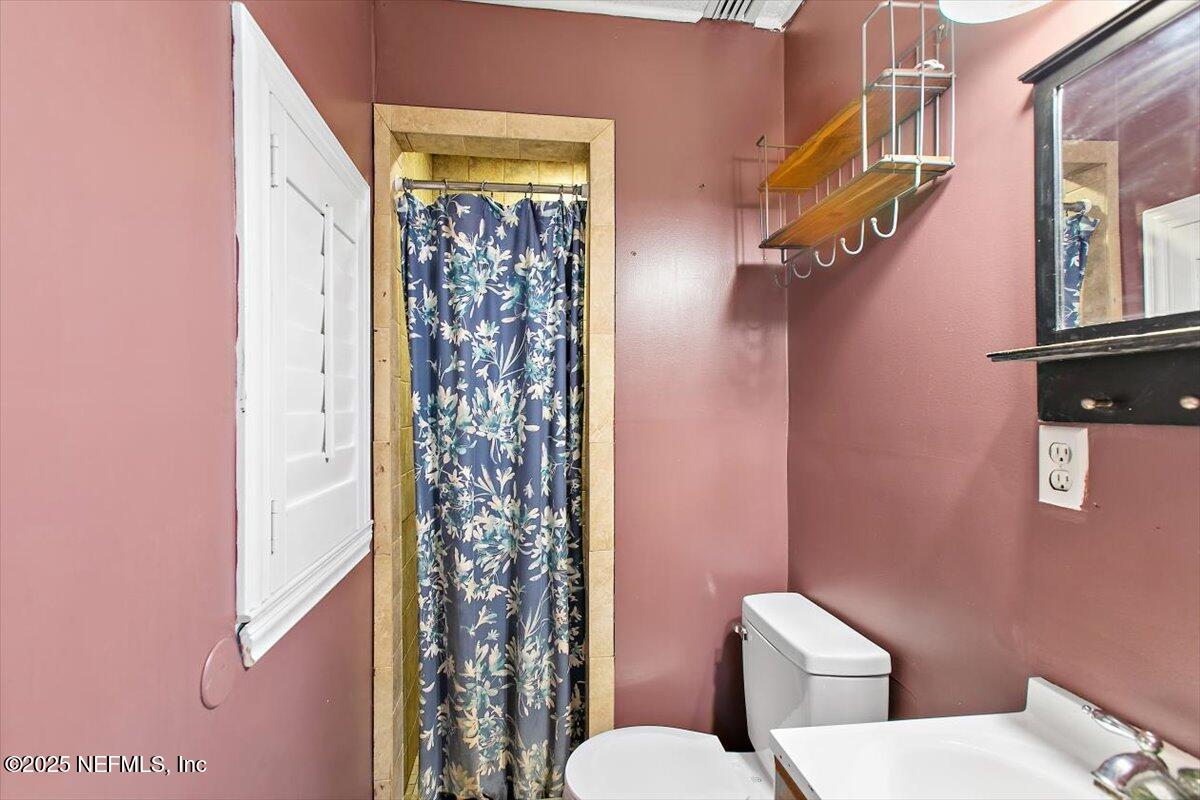 45077 Clemmons Road Callahan, FL 32011 - Photo 9 of 20 a white toilet sitting next to a shower curtain