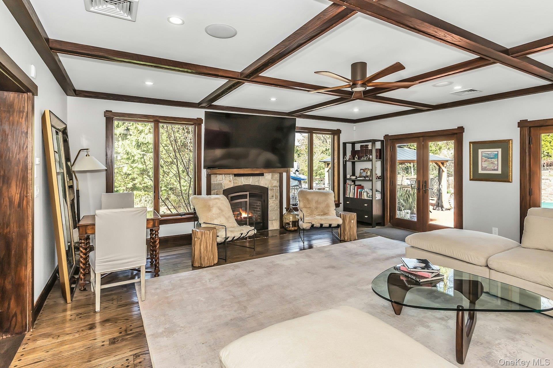 91 Crescent Beach Road Glen Cove, NY 11542 - Photo 18 of 38 a living room with furniture a fireplace and a floor to ceiling window