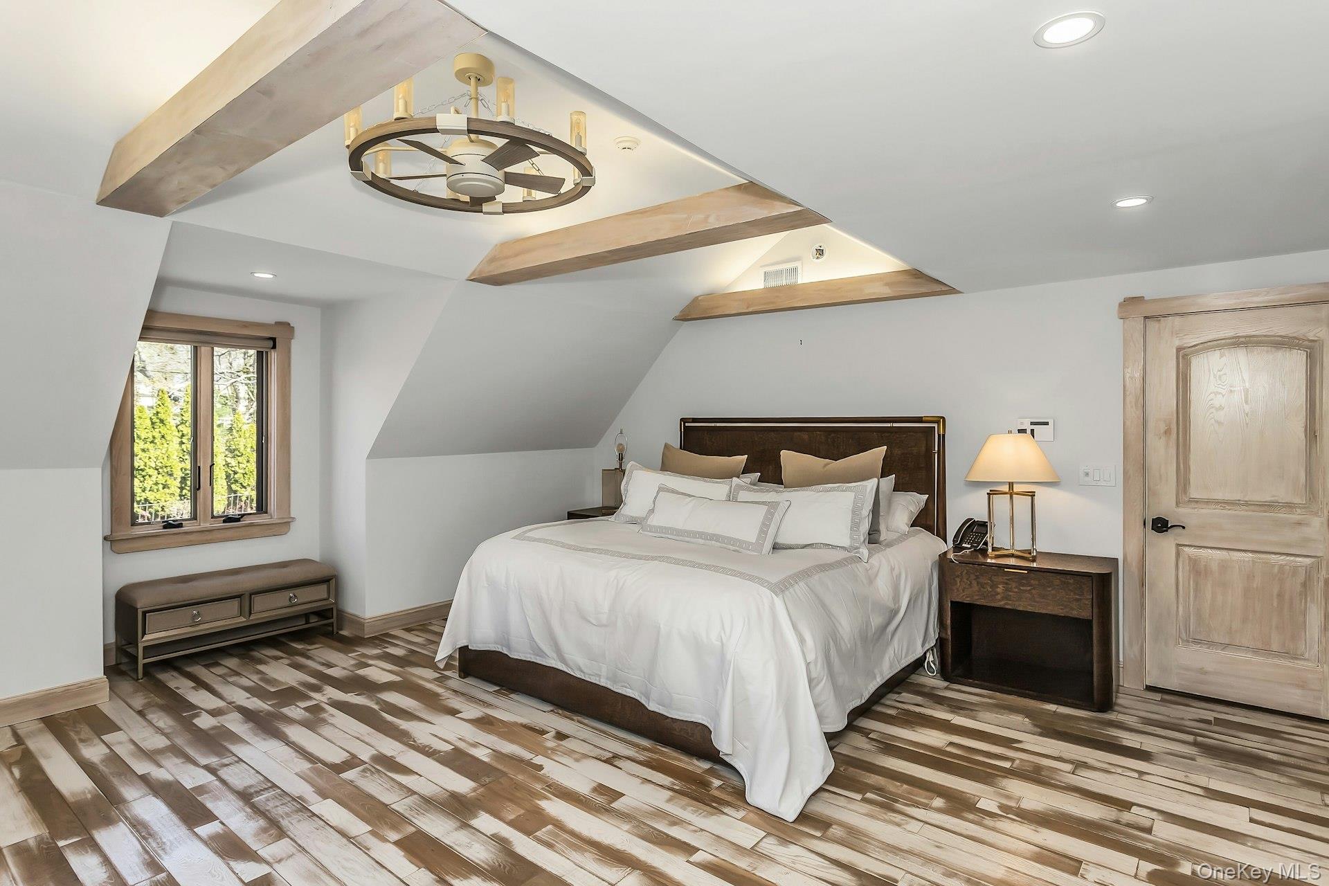 91 Crescent Beach Road Glen Cove, NY 11542 - Photo 21 of 38 a bedroom with a bed and a chandelier