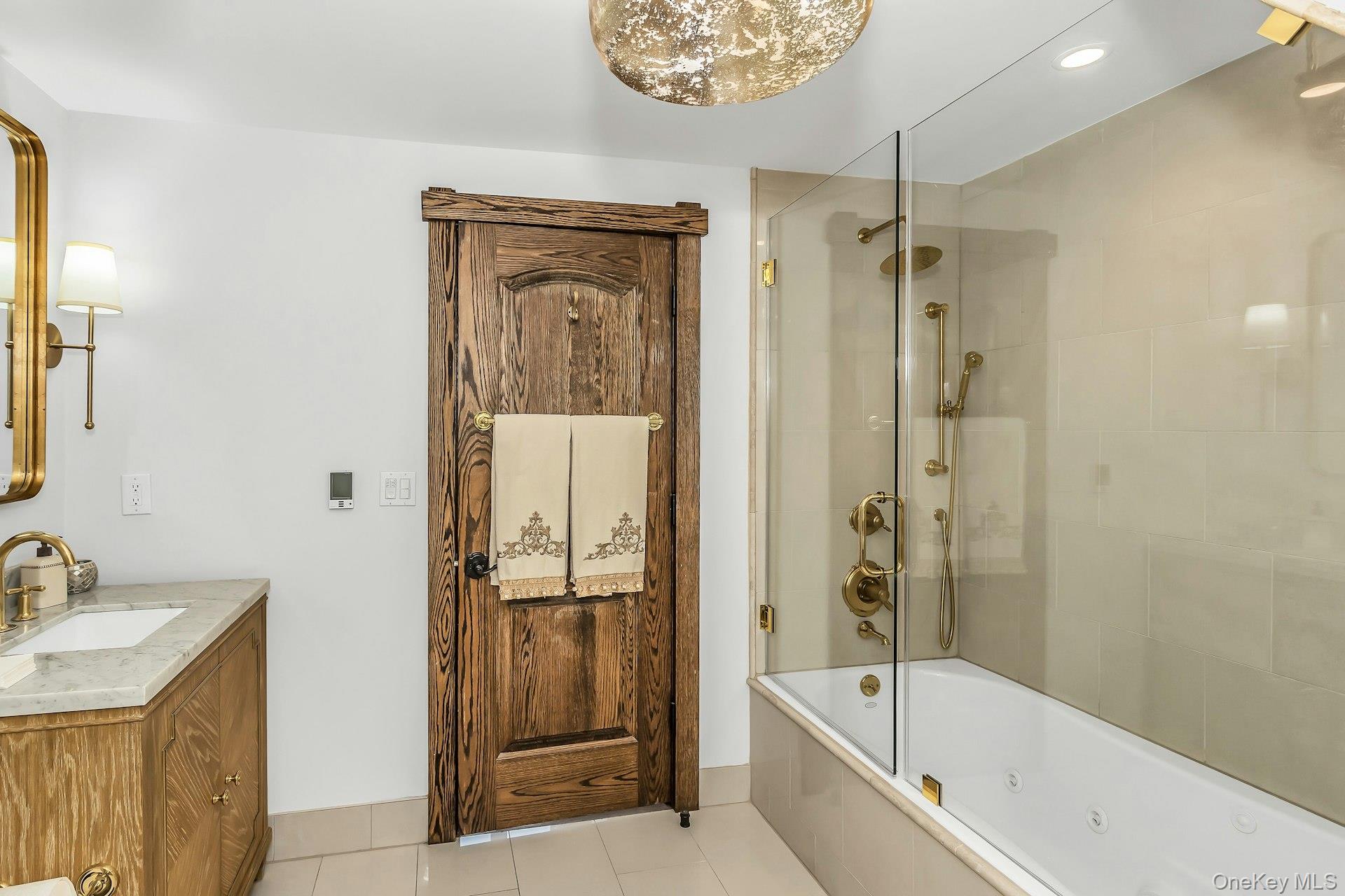 91 Crescent Beach Road Glen Cove, NY 11542 - Photo 27 of 38 a bathroom with a tub shower sink vanity granite and a shower