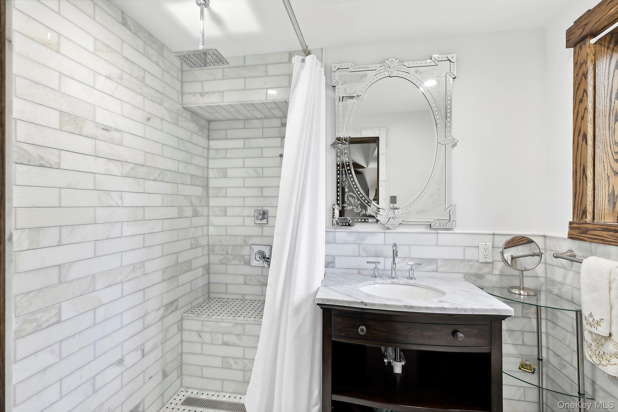 91 Crescent Beach Road Glen Cove, NY 11542 - Photo 32 of 38 a bathroom with a sink and a mirror