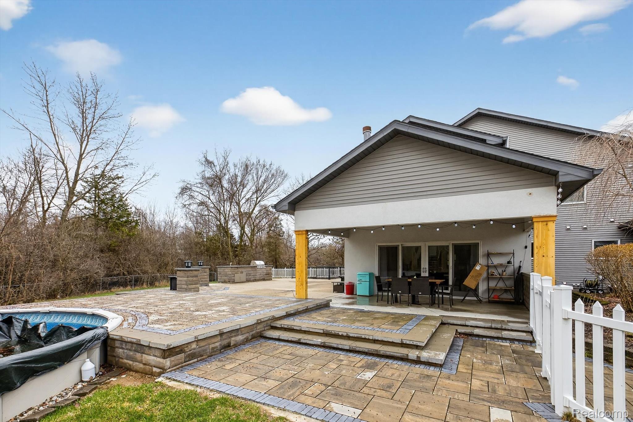 552 North McKinley Road Flushing, MI 48433 - Photo 69 of 98 Back of house with a fenced backyard, a patio, a covered pool, and stucco siding