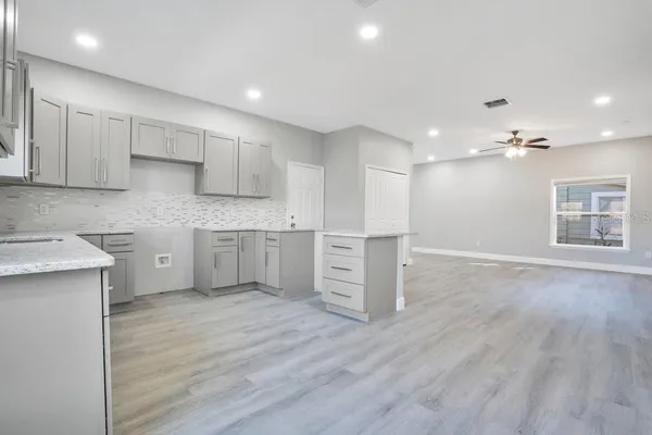a kitchen with stainless steel appliances granite countertop a sink cabinets and wooden floor