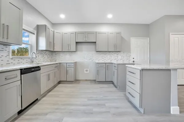 a kitchen with white cabinets stainless steel appliances and sink