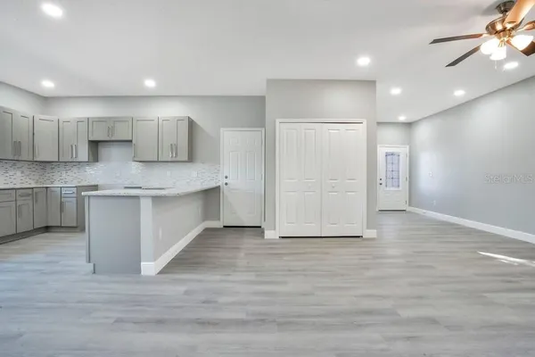 a large kitchen with stainless steel appliances granite countertop a large counter top a sink and a refrigerator