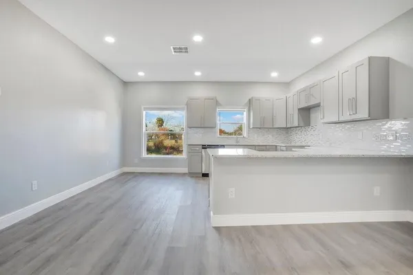 a view of kitchen with wooden floor and electronic appliances