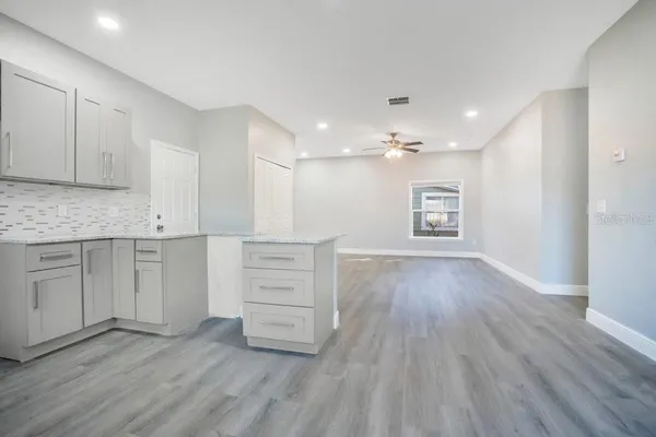 a view of a kitchen with wooden floor and electronic appliances