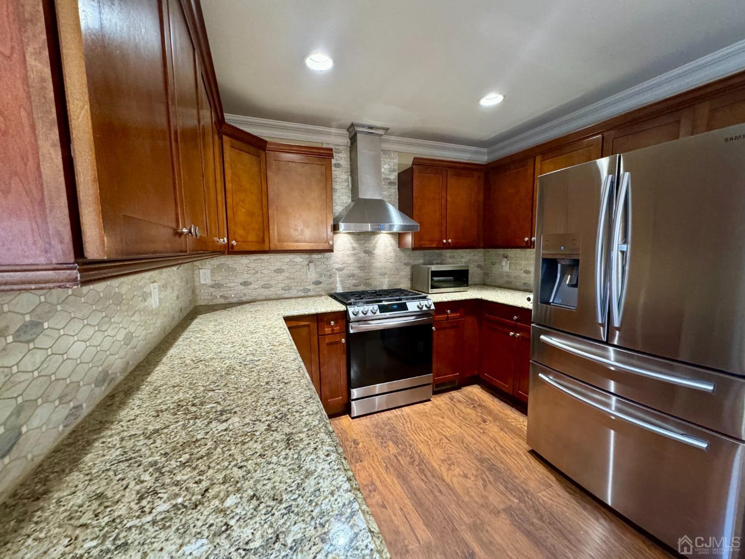 14 Baxter Road Edison, NJ 08817 - Photo 6 of 16 a kitchen with granite countertop stainless steel appliances and wooden cabinets