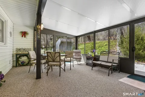 a dining room with furniture and a floor to ceiling window