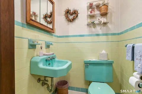 a bathroom with a toilet sink and mirror
