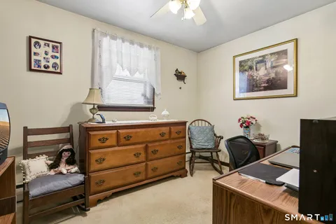 a room with a baby bed furniture and a window