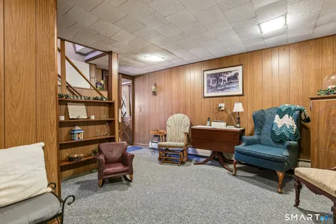 a living room with furniture a rug and a wall painting