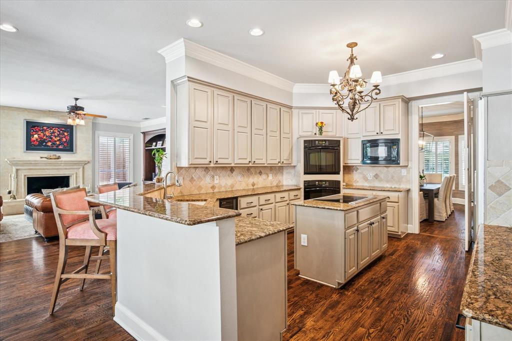 6511 Aberdeen Avenue Dallas, TX 75230 - Photo 14 of 40 a kitchen with a stove a refrigerator and a fireplace