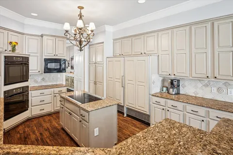 a kitchen with white cabinets and sink