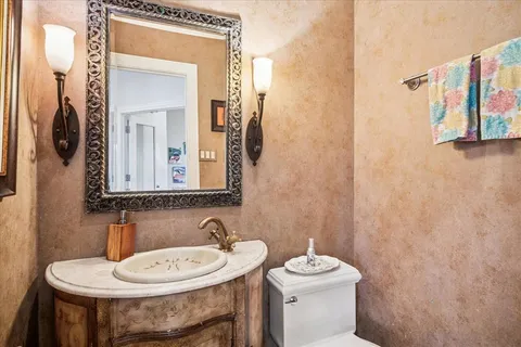 a bathroom with a sink a toilet and a mirror