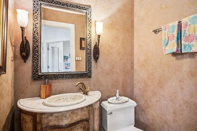 a bathroom with a sink a toilet and a mirror