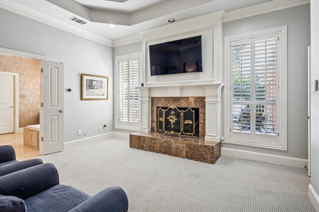 6511 Aberdeen Avenue Dallas, TX 75230 - Photo 22 of 40 a living room with furniture a fireplace and a flat screen tv