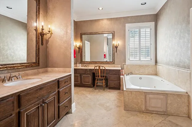 a bathroom with a tub double vanity sink and a large mirror