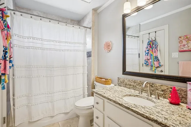 a bathroom with a granite countertop sink and a shower curtain