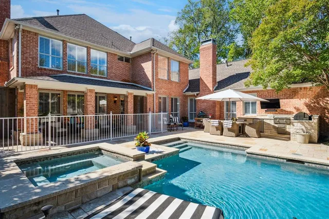 a front view of a house with swimming pool garden and patio