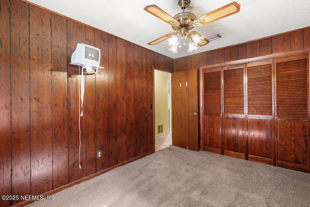 5342 Hickson Road Jacksonville, FL 32207 - Photo 9 of 19 an empty room with wooden floor and fan