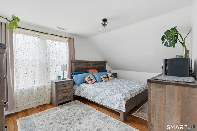 a bedroom with a bed and a potted plant
