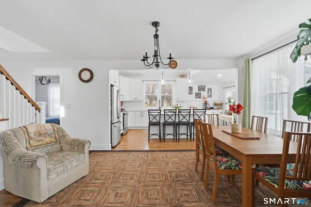 a living room with furniture a dining table and a rug