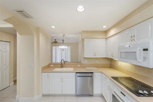 a kitchen with granite countertop a sink stove and cabinets
