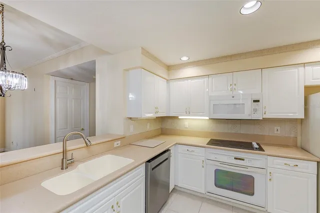 a kitchen with granite countertop white cabinets and white appliances