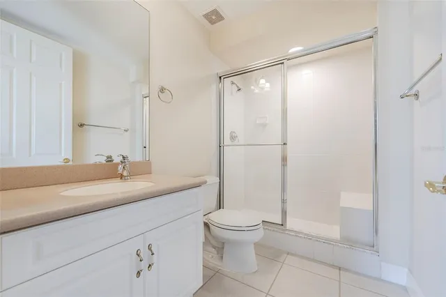 a bathroom with a granite countertop sink toilet a mirror and shower