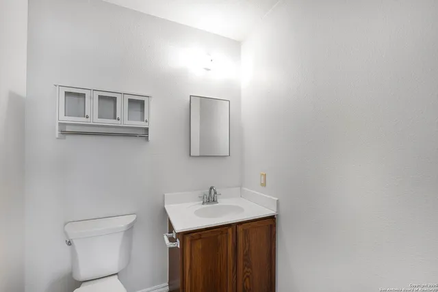a bathroom with a toilet a sink and mirror