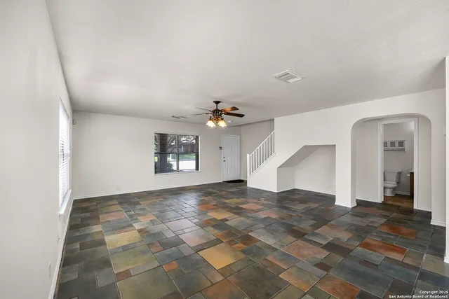 an empty room with windows and cabinet