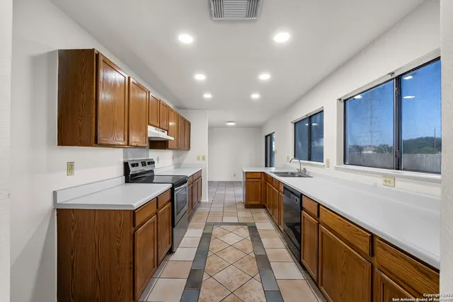 a large kitchen with stainless steel appliances lots of counter space and a sink