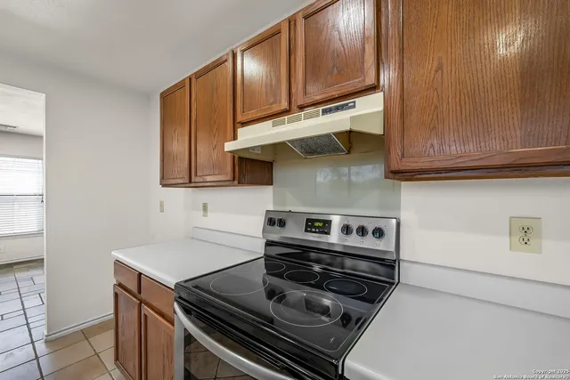 a kitchen with wooden cabinets and a stove top oven