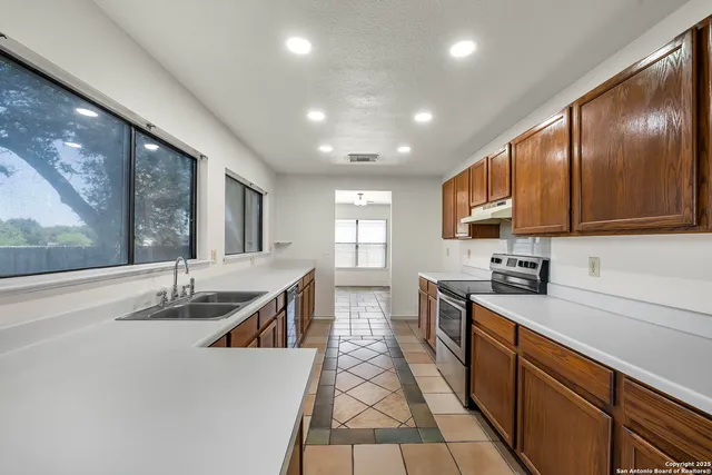 a kitchen with granite countertop sink cabinets and stainless steel appliances